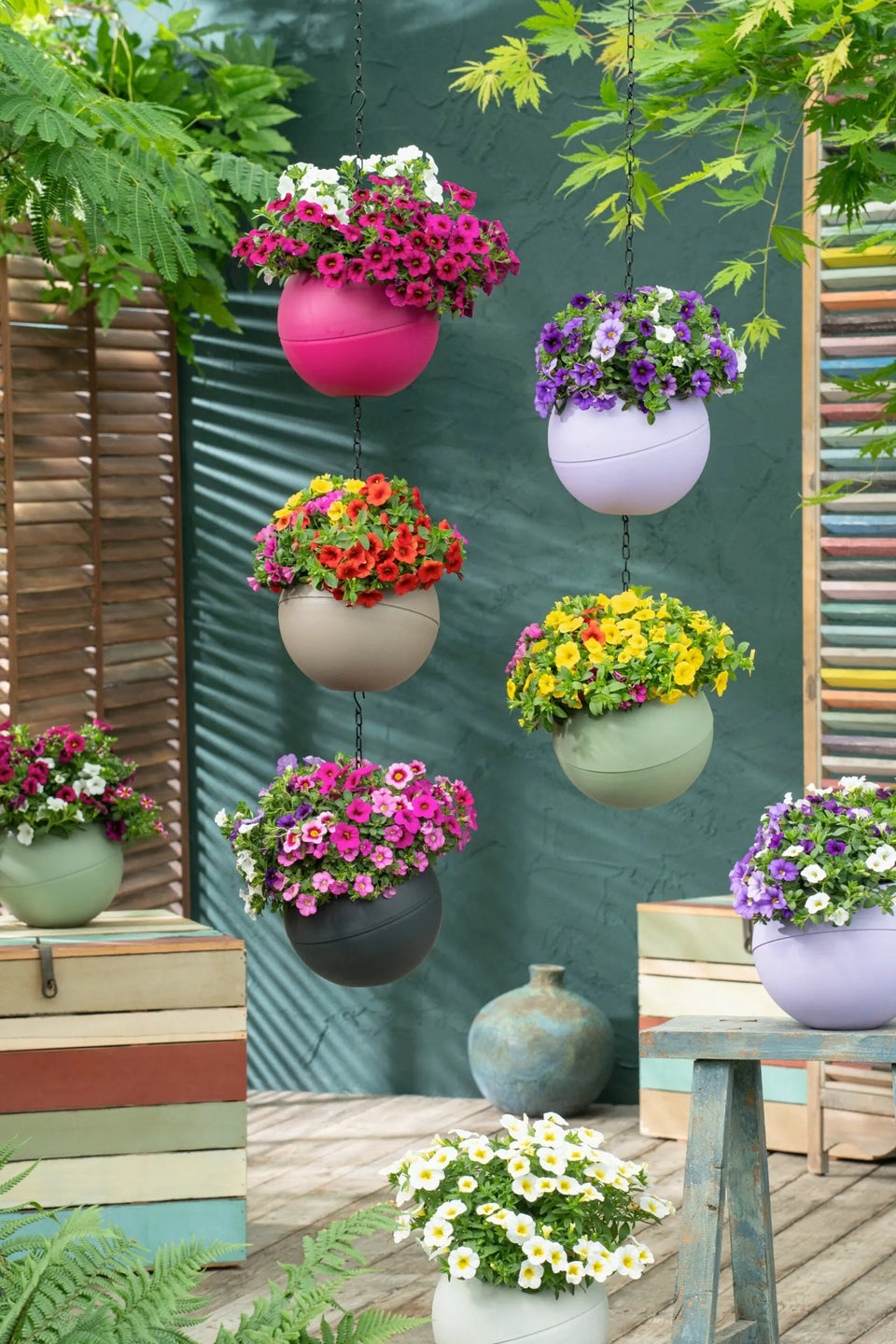 Globees in verschillende kleuren met bloeiende planten hangen onder elkaar aan kettingen